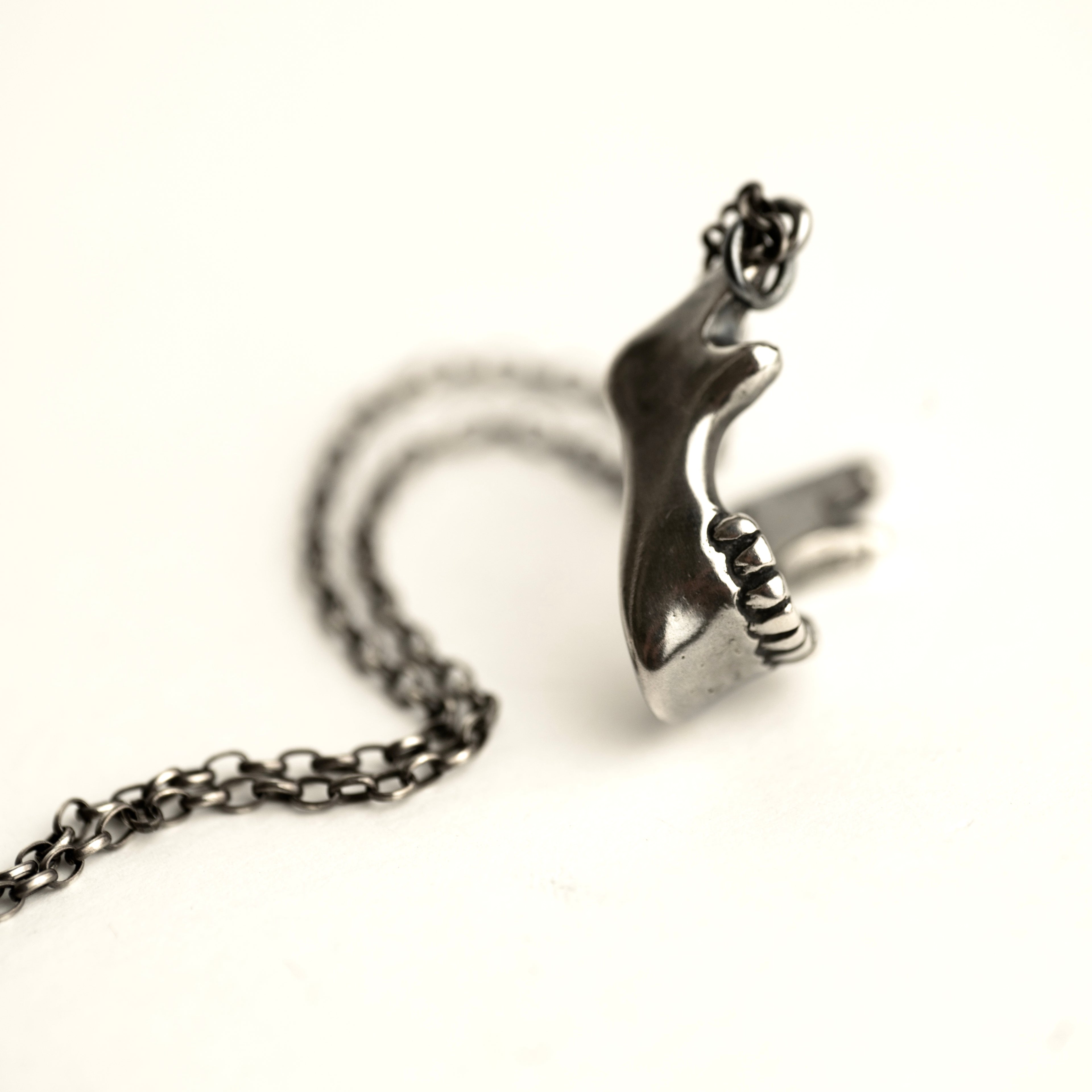 Silver Skull Jaw masculine pendant handcrafted by Macabre Gadgets featuring dramatic mirror-polished texture of the solid sterling silver jewelry