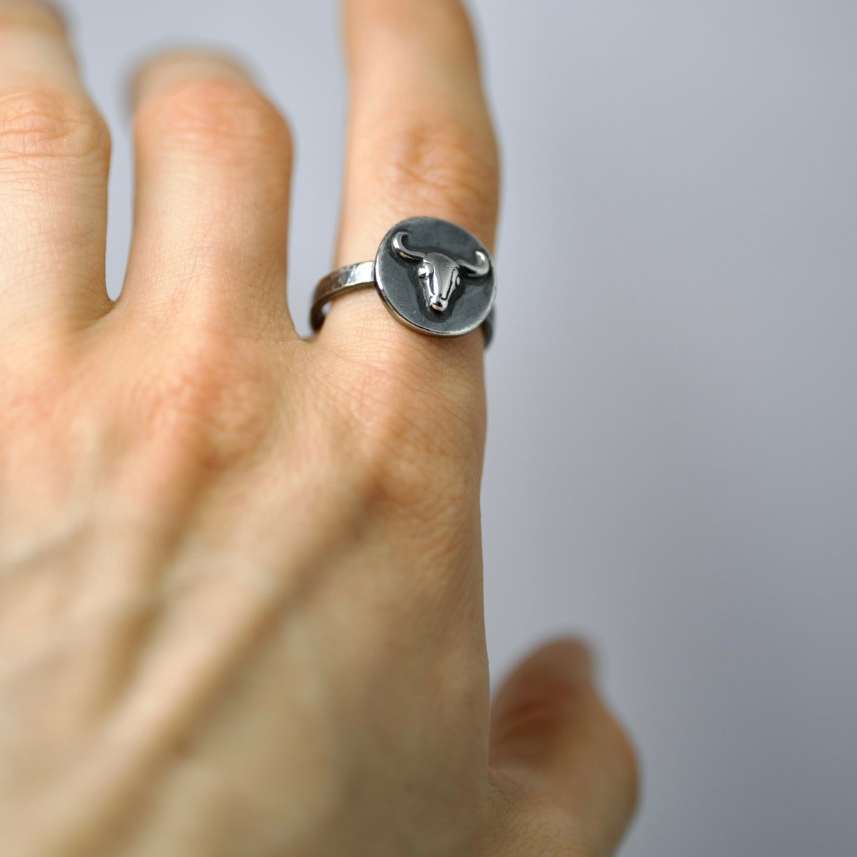 Male model wearing Bull Ancient Coin ring - Odyssey-inspired silver ring with taurus relief