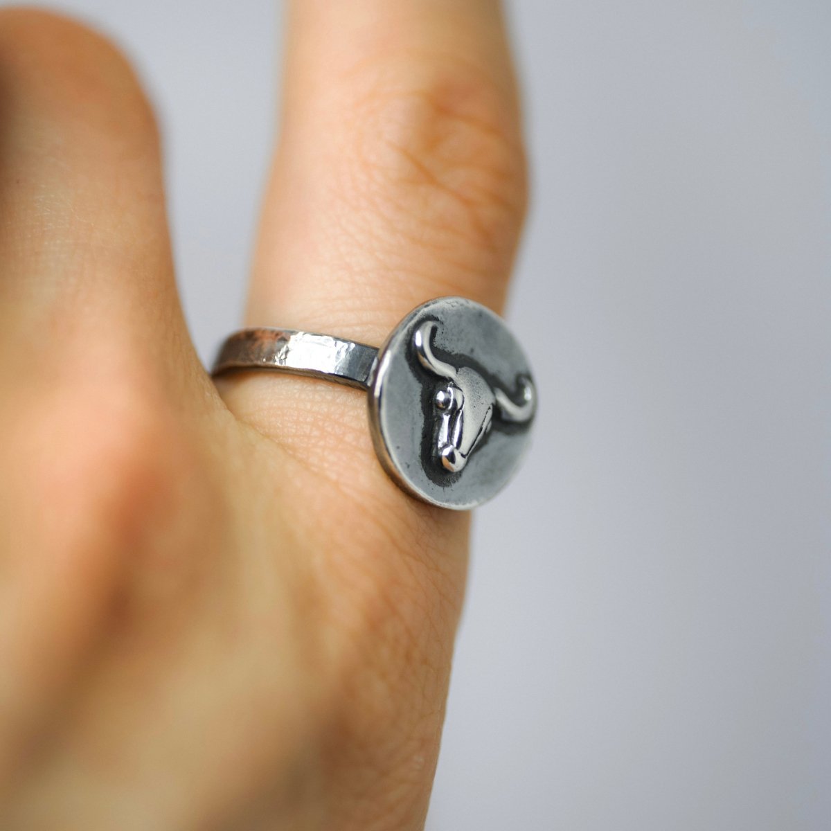 Close-up of Bull Ancient Coin ring on a person hand - ancient roman gladiator-inspired silver coin ring