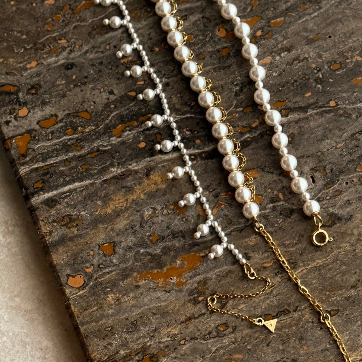 Pearl Net choker and Aegean Pearl choker placed on marble board next to each other - lifestyle shoot