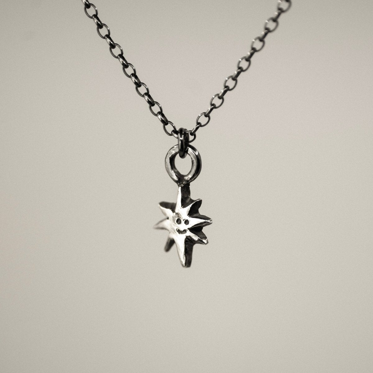 Smiling Star mini pendant - close-up of silver star charm on neutral background