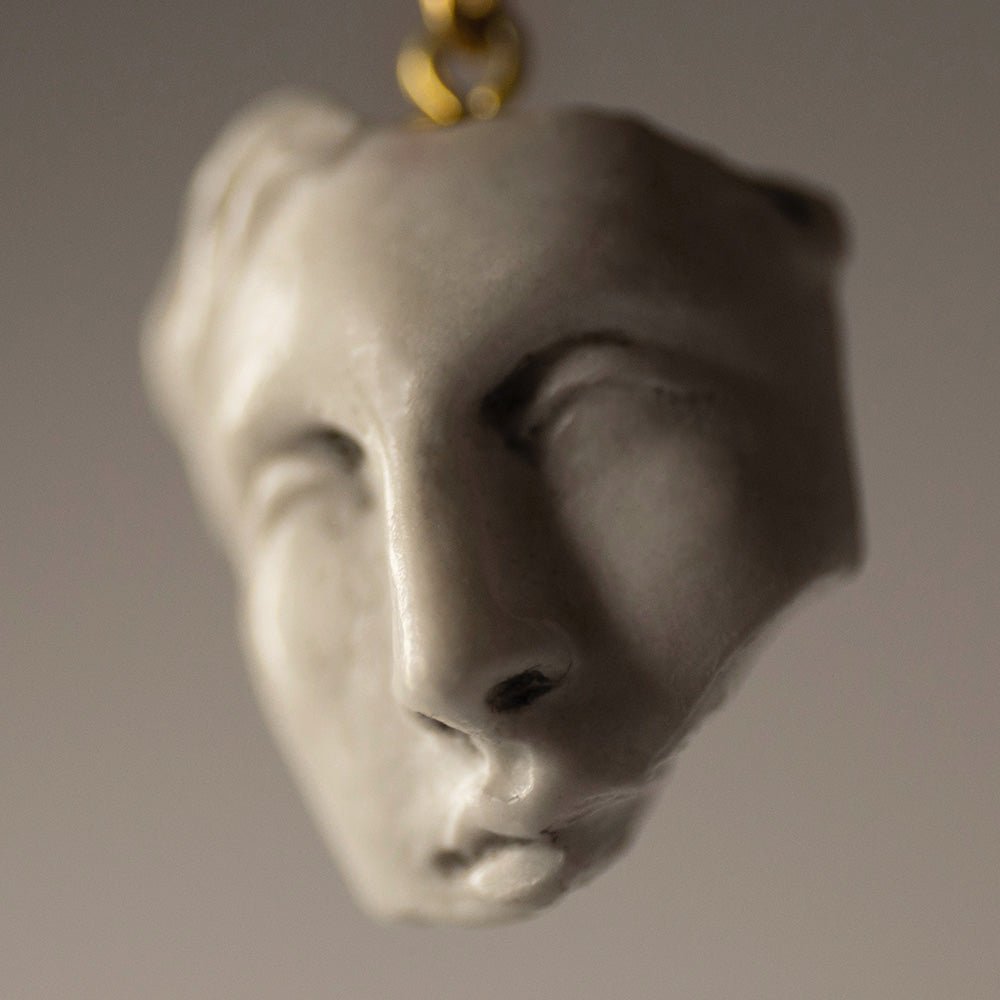 Close-up of Helen pendant - marble charm in shape of sculptured face fragment