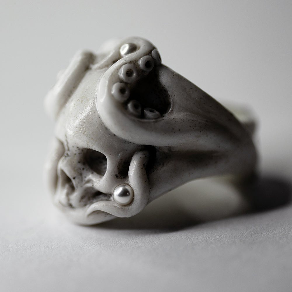 Octopus Skull ring - white netsuke-like gothic ring featuring octopus grasping a skull on neutral background