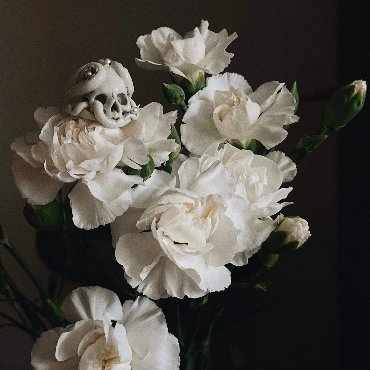 Octopus Skull ring placed between white flower petals  - life stile editorial