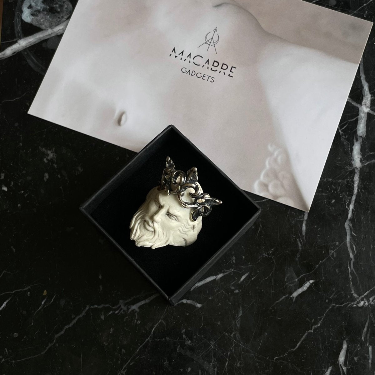 Poseidon ring in a jwelry box on a black marble surface - greek god jewelry lifestyle shot
