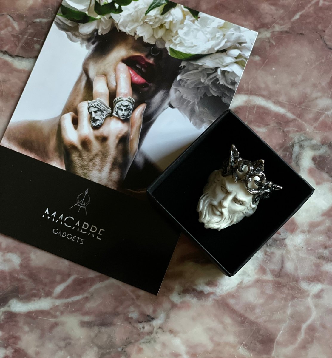 Poseidon ring in a jewelry box, on pink marble background - mythology inspired lifestyle shot