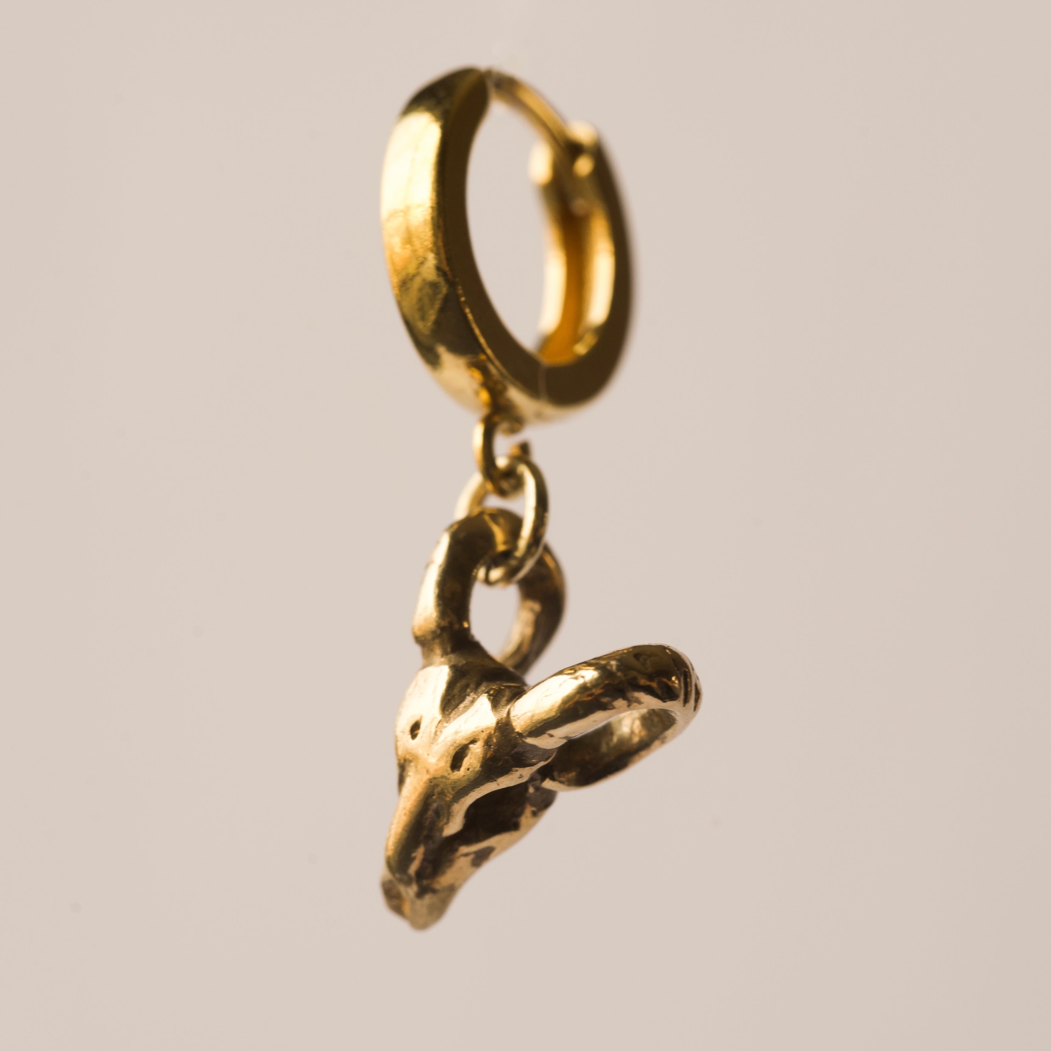 Golden Ram Skull earring by Macabre Gadgets on a white background