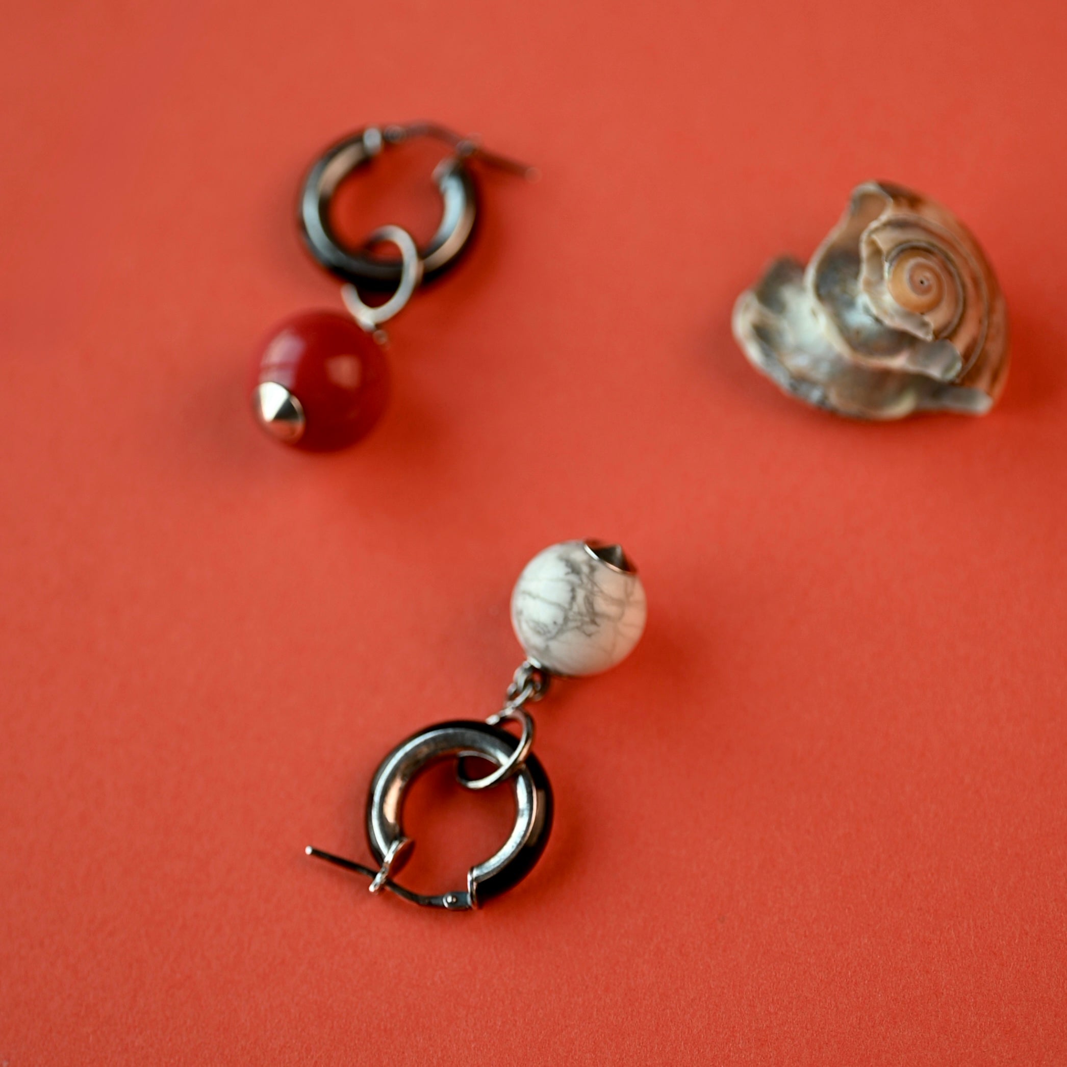 Pair of earrings with beads on a red background