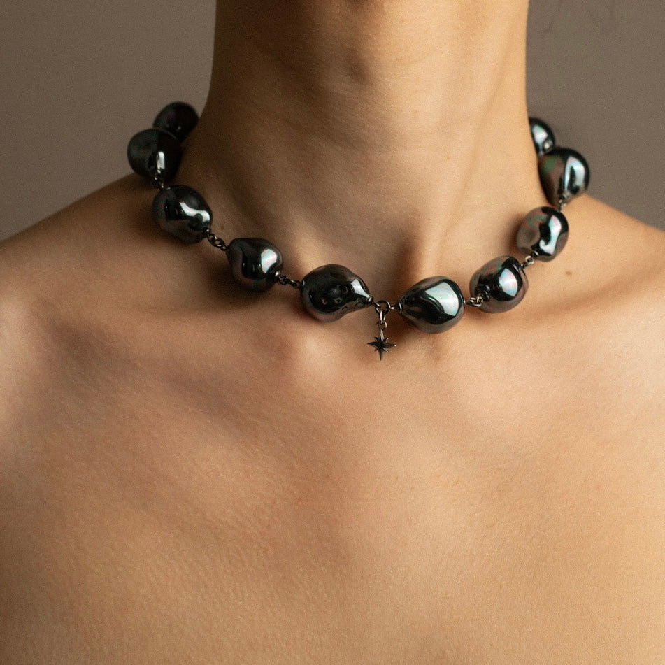 Black large pearl necklace by Macabre Gadgets on a person's neck against a neutral background - siren or mermaid style jewelry