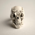 White skull ring with vampire fangs resembling an Orchid flower on a light gray background
