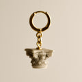 Corinth earring - gold hoop with decorative Corinth column element on beige background