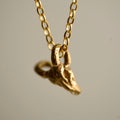 Ram Skull pendant - golden chain necklace with a mini charm on a neutral background