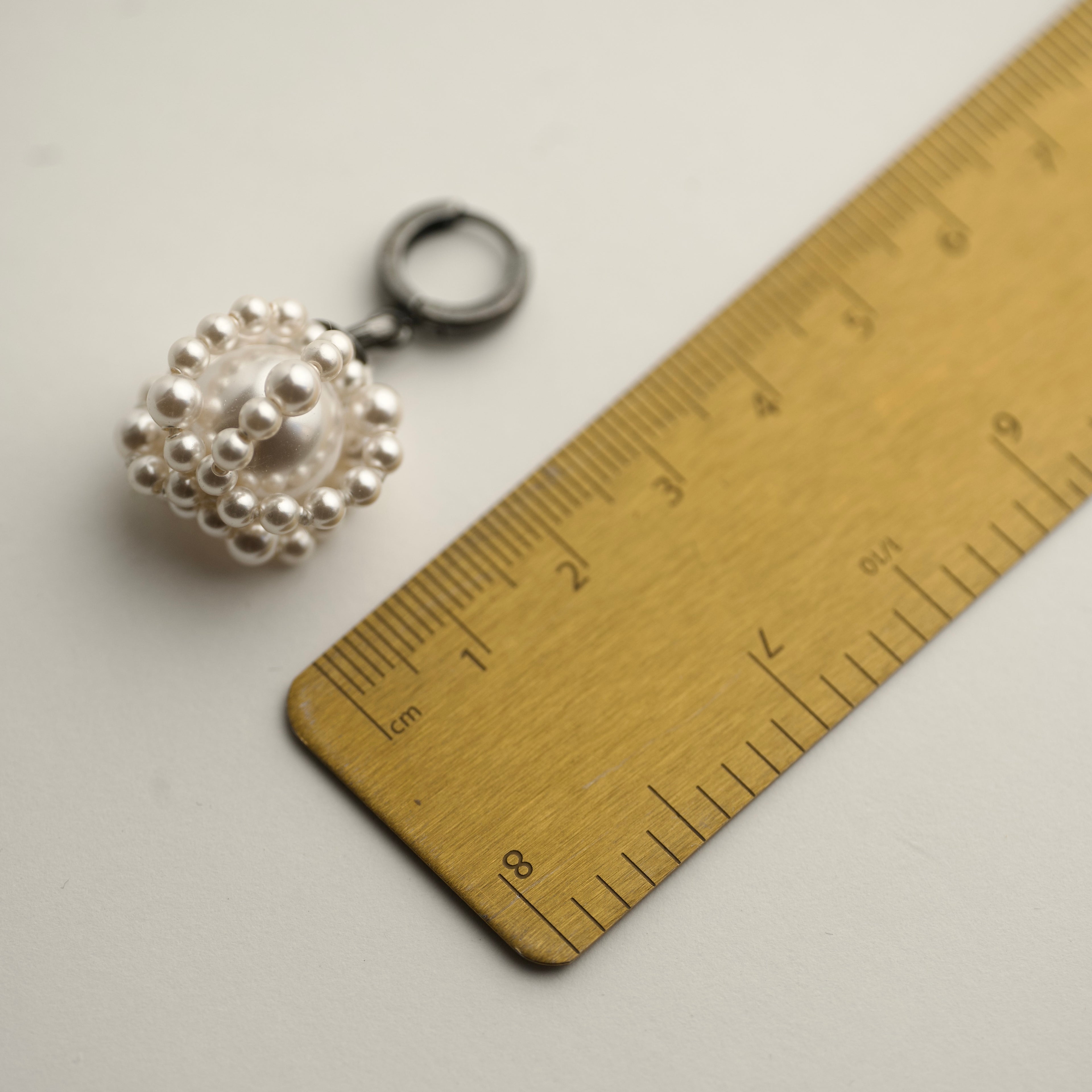 Comparison shot of a Pearl Cloud earring - Pearl earring on hoop - by Macabre Gadgets and a ruler to showcase its size