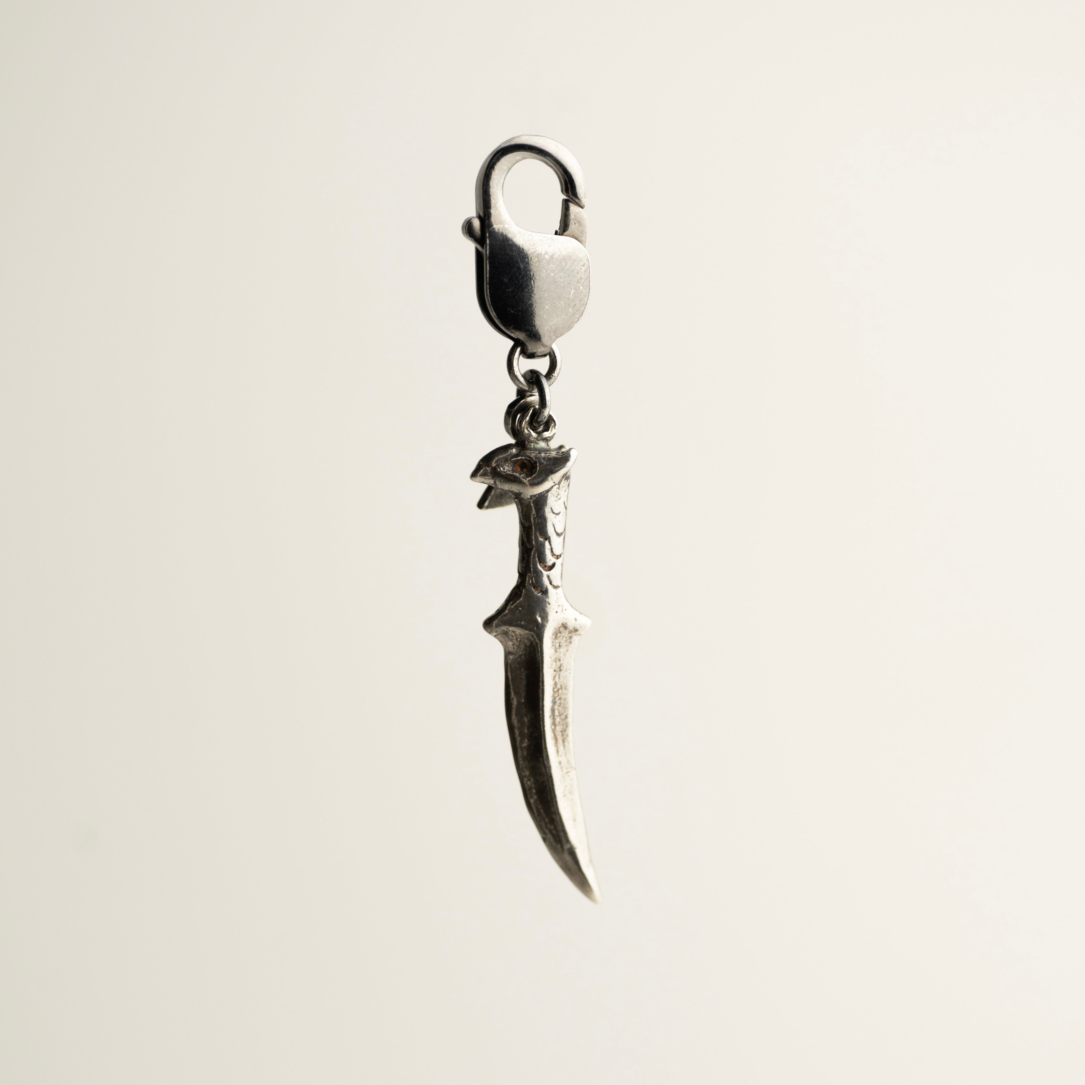 Griffin charm - sterling silver dagger-shaped charm on a white background