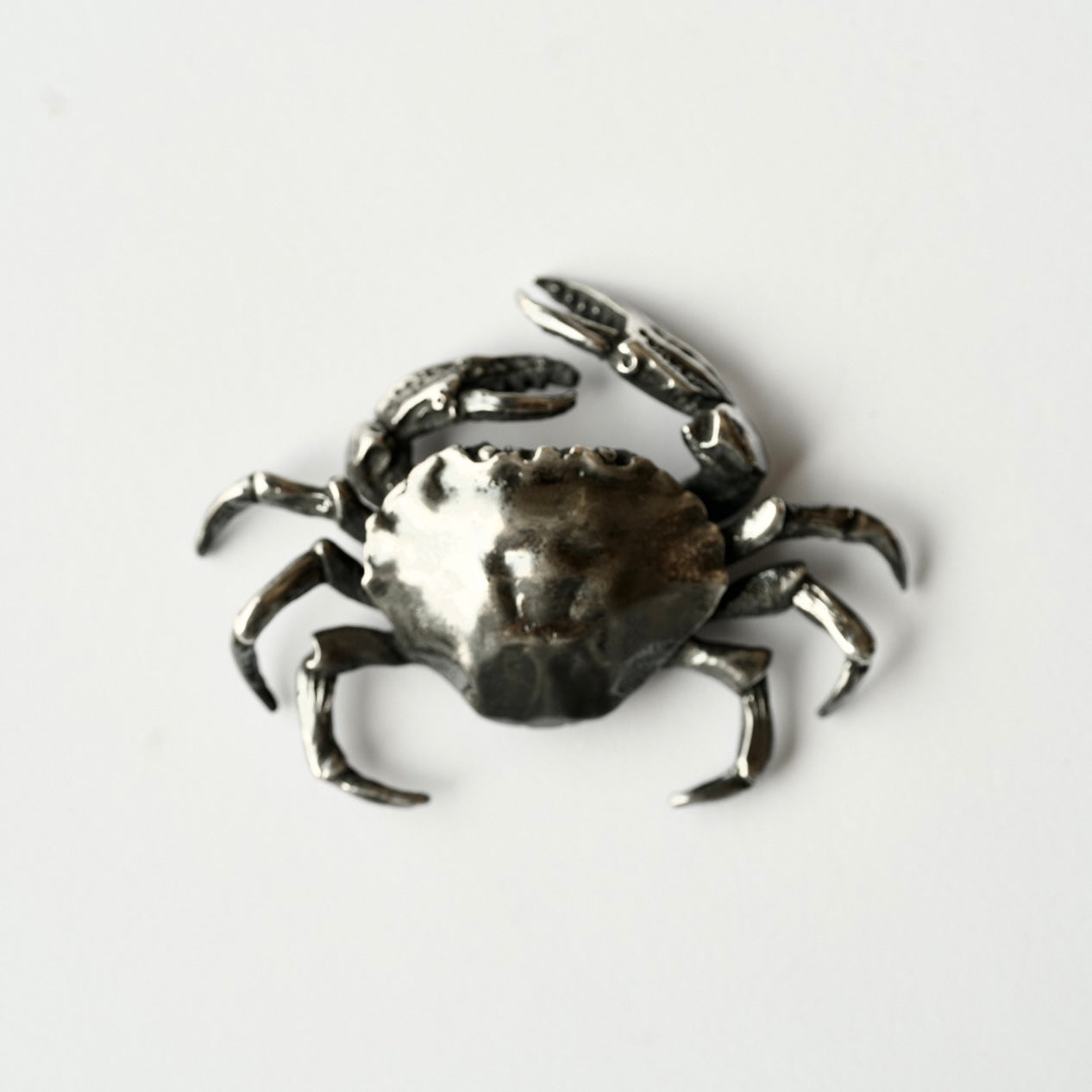 Solid sterling silver crab-shaped brooch hand crafted by Macabre Gadgets on a white background
