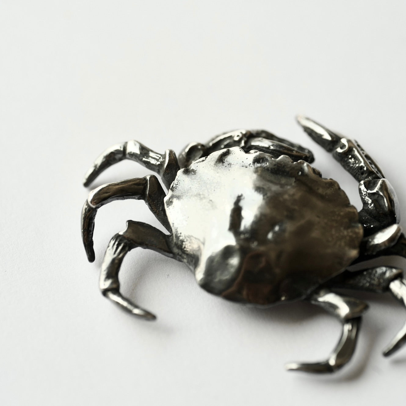 Silver crab-shaped brooch - siren core jewelry - on a white background