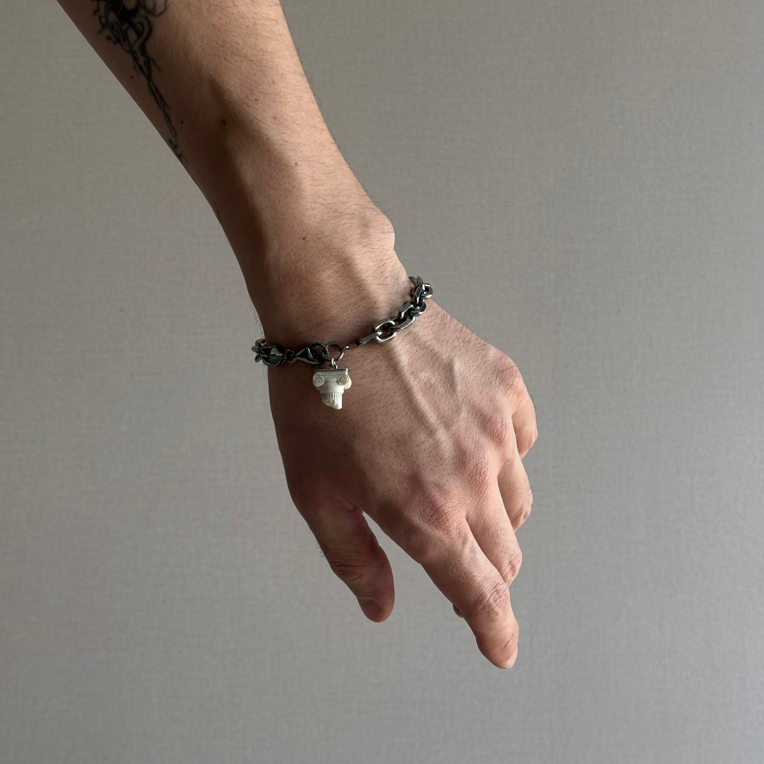Ionic bracelet by Macabre Gadgets is a heavy and massive stapled sterling silver anchor chain with a small Ancient Greek inspired marble column in white marble - male model is wearing the bracelet - perfect masculine mens jewelry