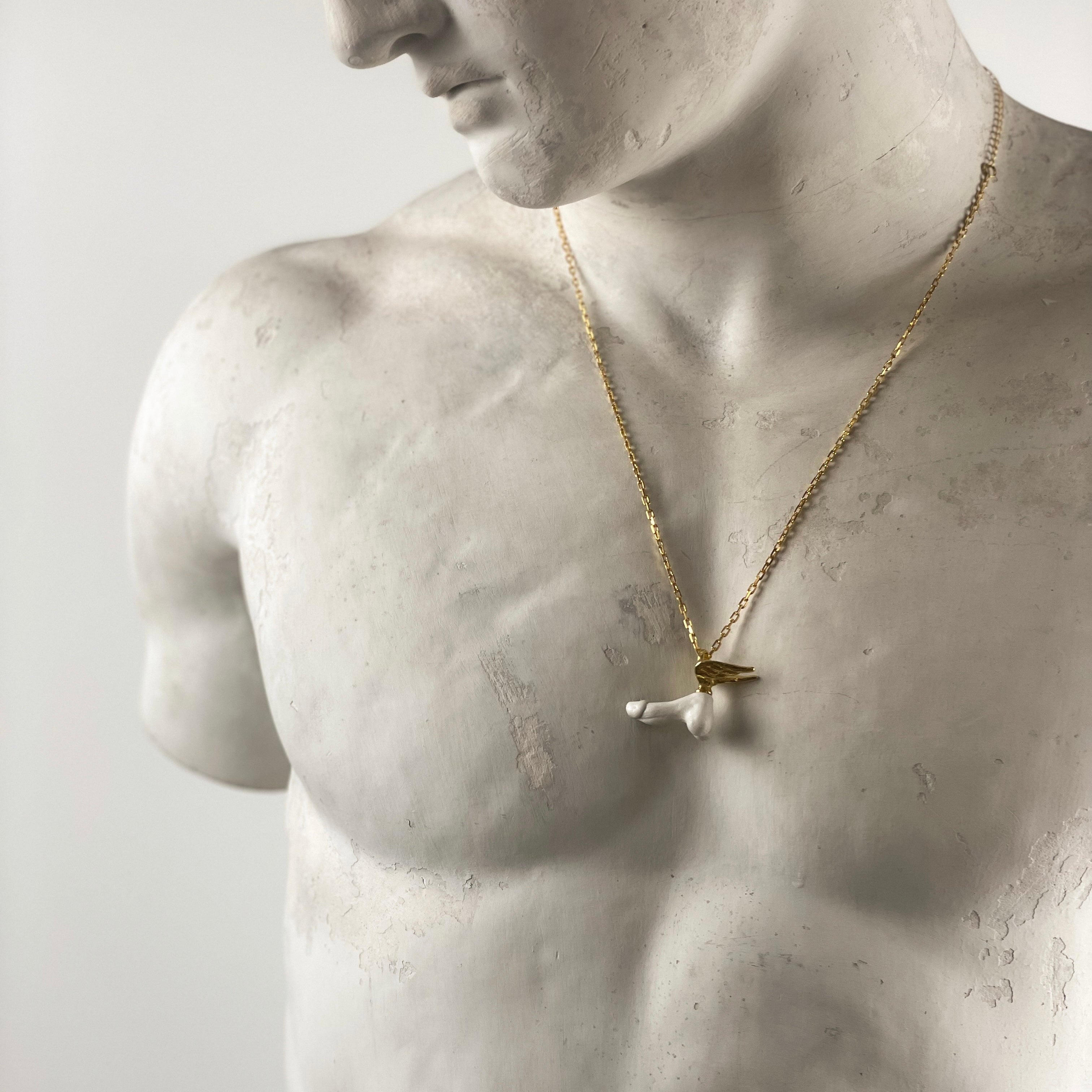 Fascinus pendant - phallic symbol on gold chain, on a white marble statue of an Ancient Greekathlete