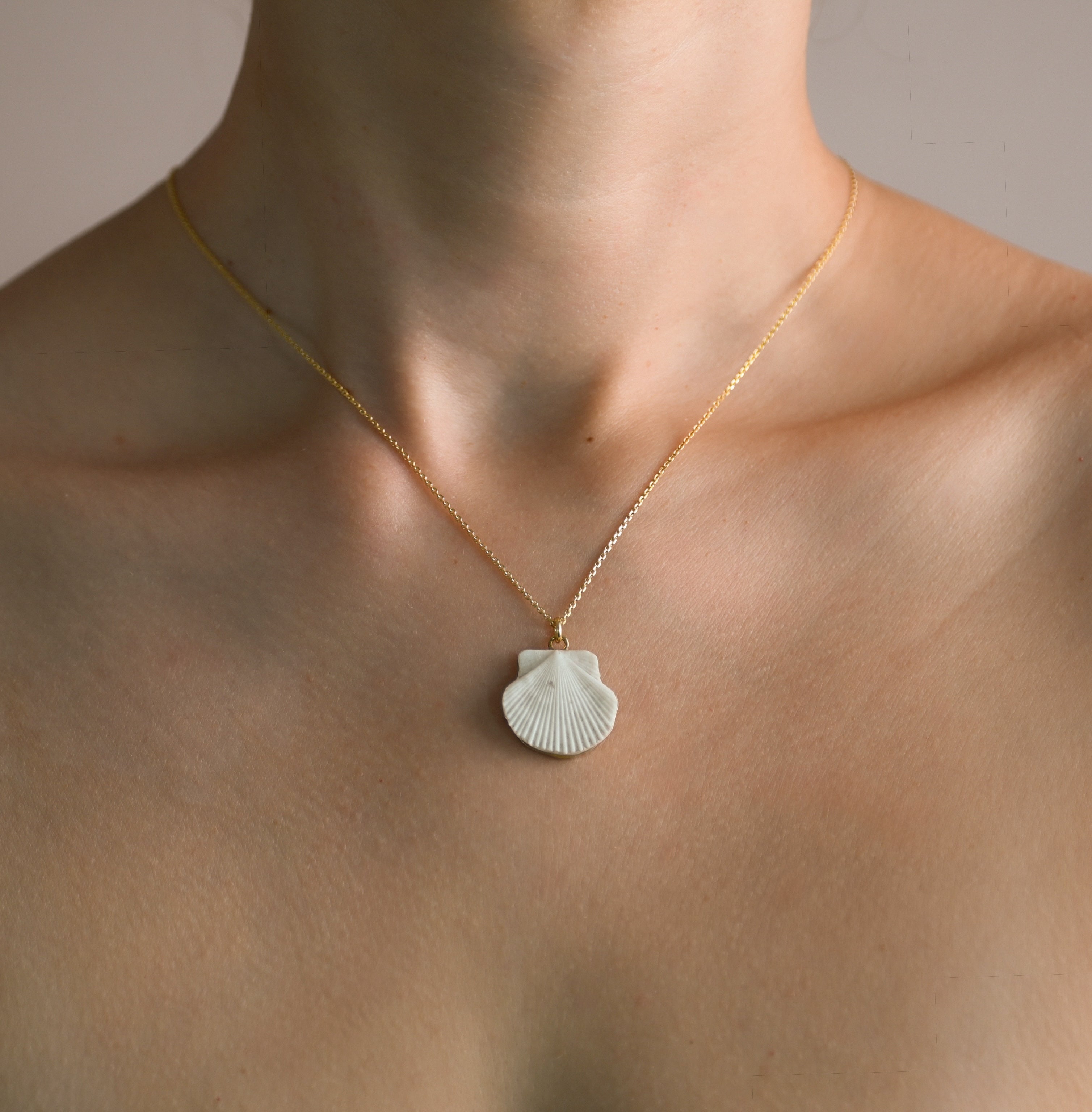 Chain with a shell pendant on a person's neck against a neutral background: Sea Shell pendant hand crafted by Macabre Gadgets - Venus or Aphrodite inspired jewelry