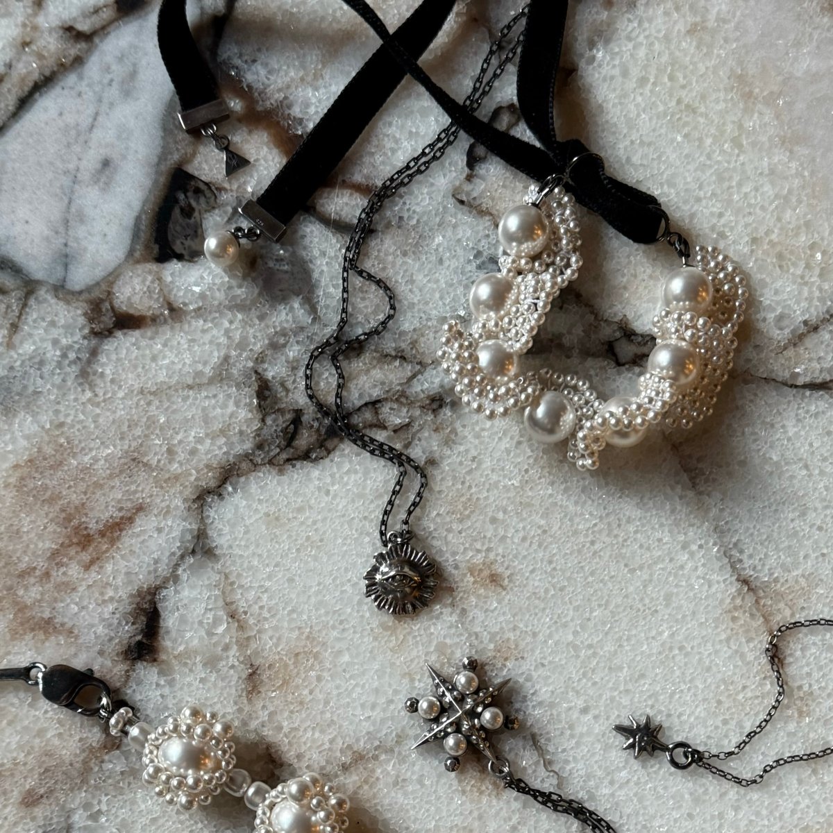 Sirius pendant with other jewelry on a marble surface