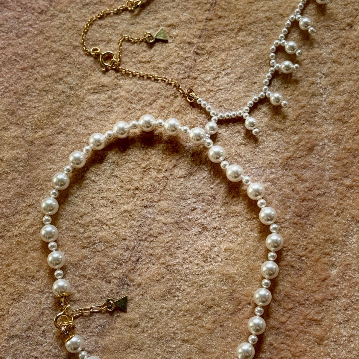 Aegean Pearl choker on a raw stone surface in a resort, summer mood