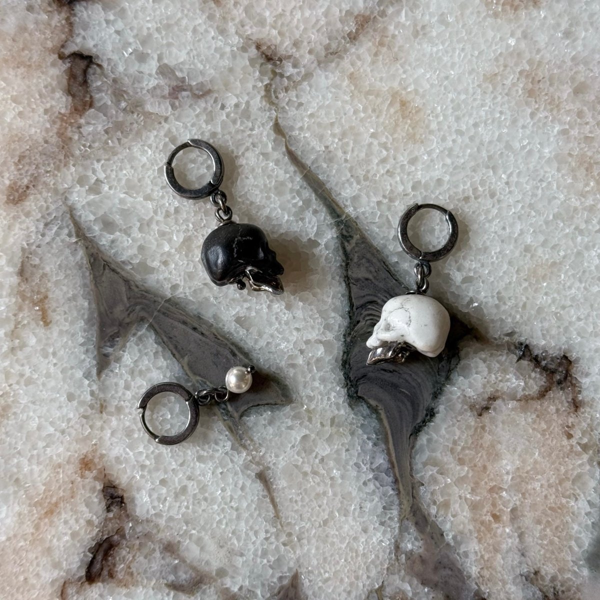 Ancient Skull earring - black and white variant on a marble surface