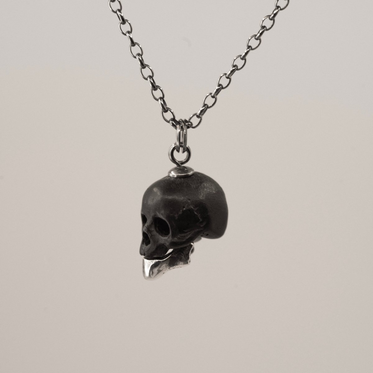 Ancient Skull pendant - black variant - semi-profile view against white background