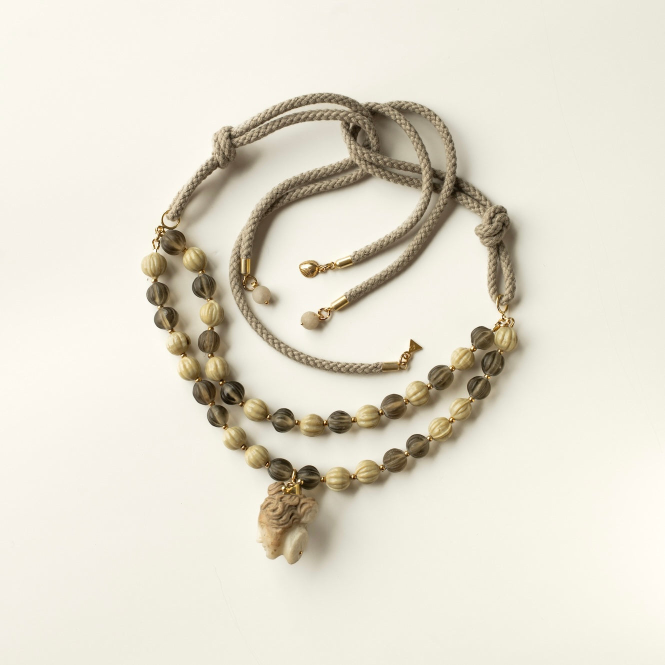 Necklace with beads and a marble Aphrodite pendant on a white
 background - full wiev