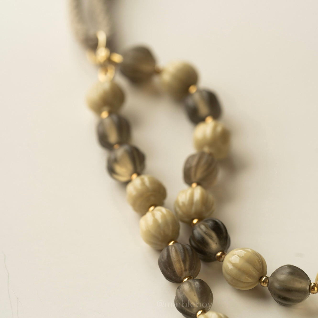 Necklace with bottle green and olive beads on a light background