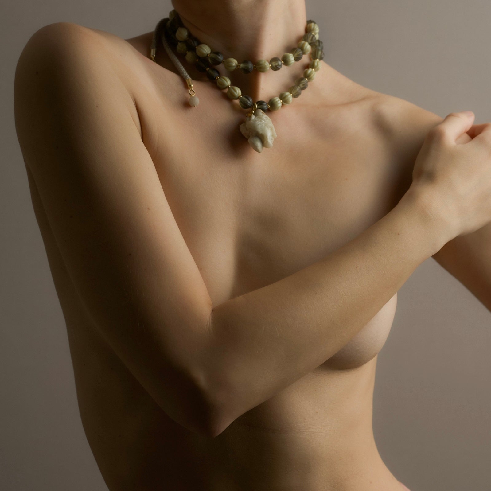 Female model wearing a beaded Aphrodite necklace by Macabre Gadgets against a neutral background - editorial shot on a person resembling ancient statues of Aphrodite/Venus