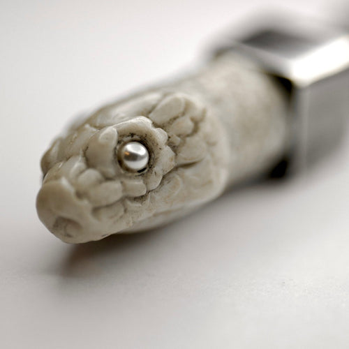Aspis snake pendant white variant - close up on pearl eye of the snake