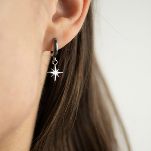 Asteria Small silver Star earring on a female model with long hair