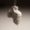 Skull & Bat pendant - a small netsuke skull - white variant - focus on the bat's wing covering the skull's face