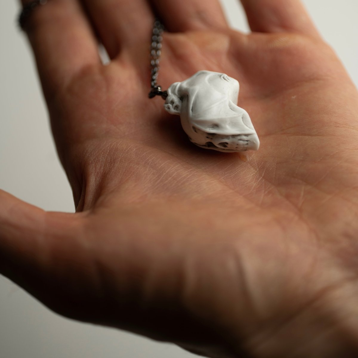 Skull & Bat pendant on a palm of the hand, for better dimension representation