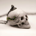 Beetles Skull pendant — white marble variant — on white surface showing skull detail, sterling silver chain and floral holder fixture