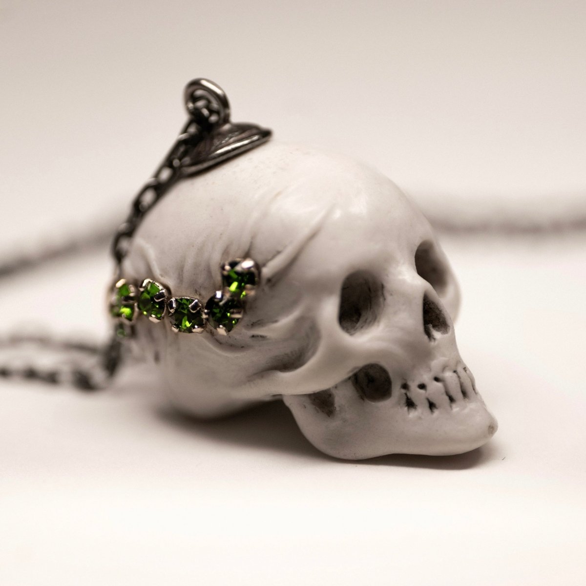 Beetles Skull pendant — white marble variant — on white surface showing skull detail, sterling silver chain and floral holder fixture