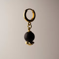 Blueberry earring gold variant on neutral background with contrast lighting, black onyx stone earring detail
