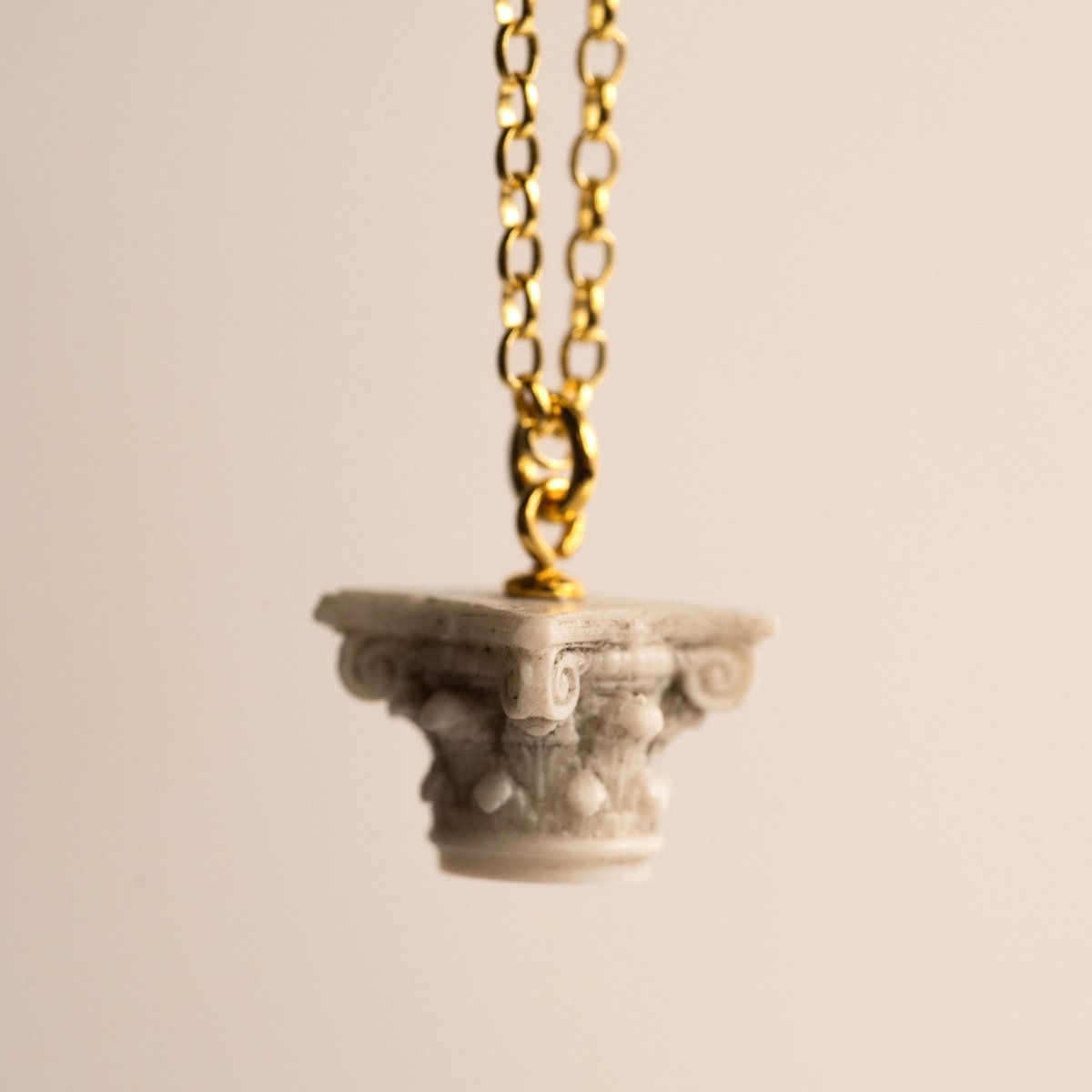 Corinth pendant against white background, with focus on the pendant's delicate details
