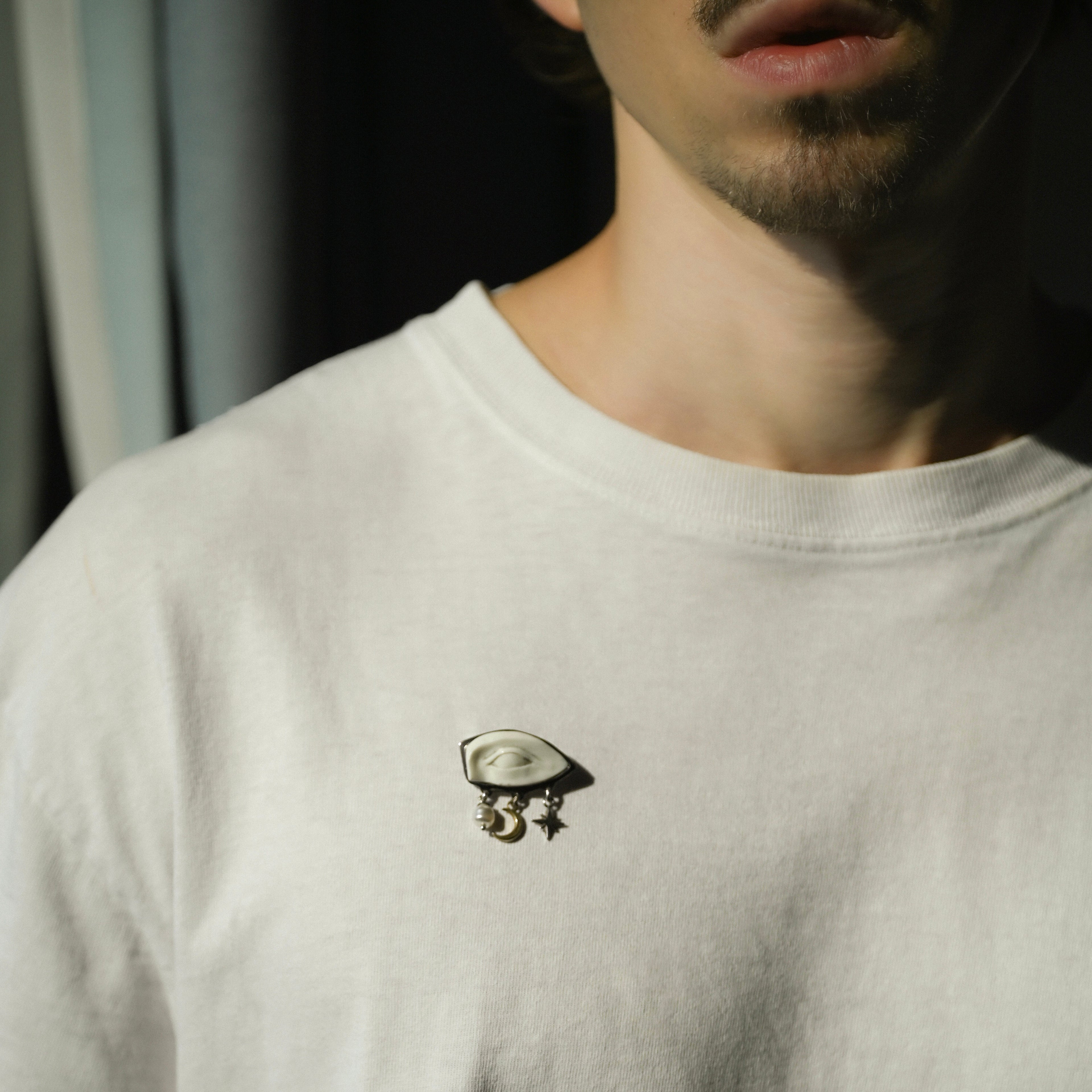 Gaze brooch by Macabre Gadgets - is a handcrafted piece of art and sculpture you can wear. Shown on male model in white t-shirt