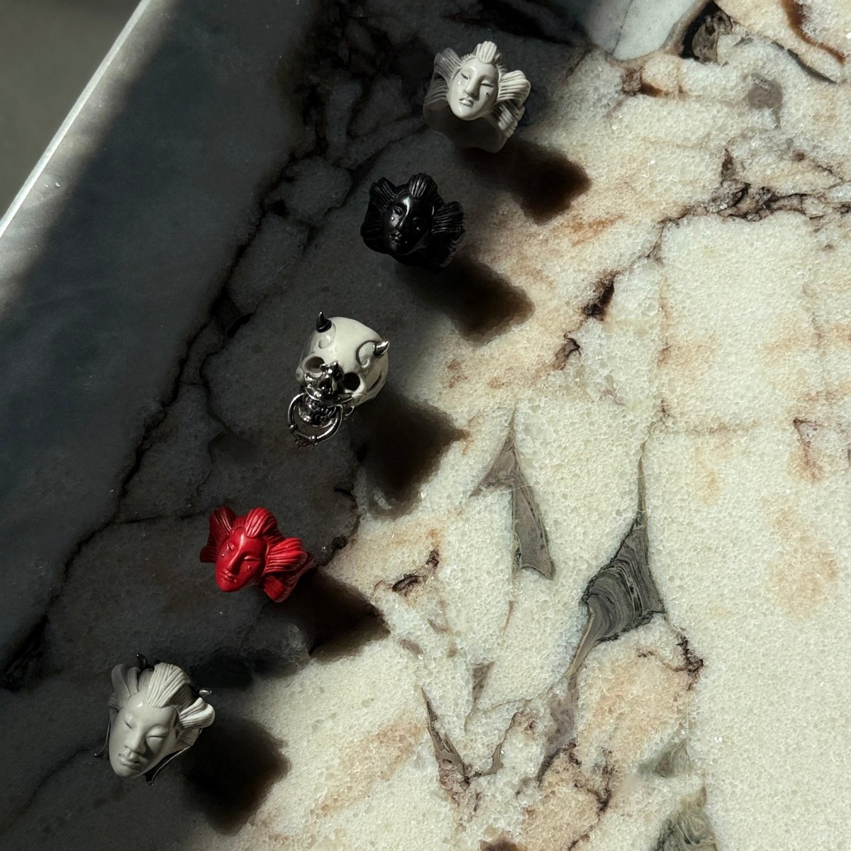 Ghost ring along with other rings by Macabre Gadgets on a light marble surface - different angle