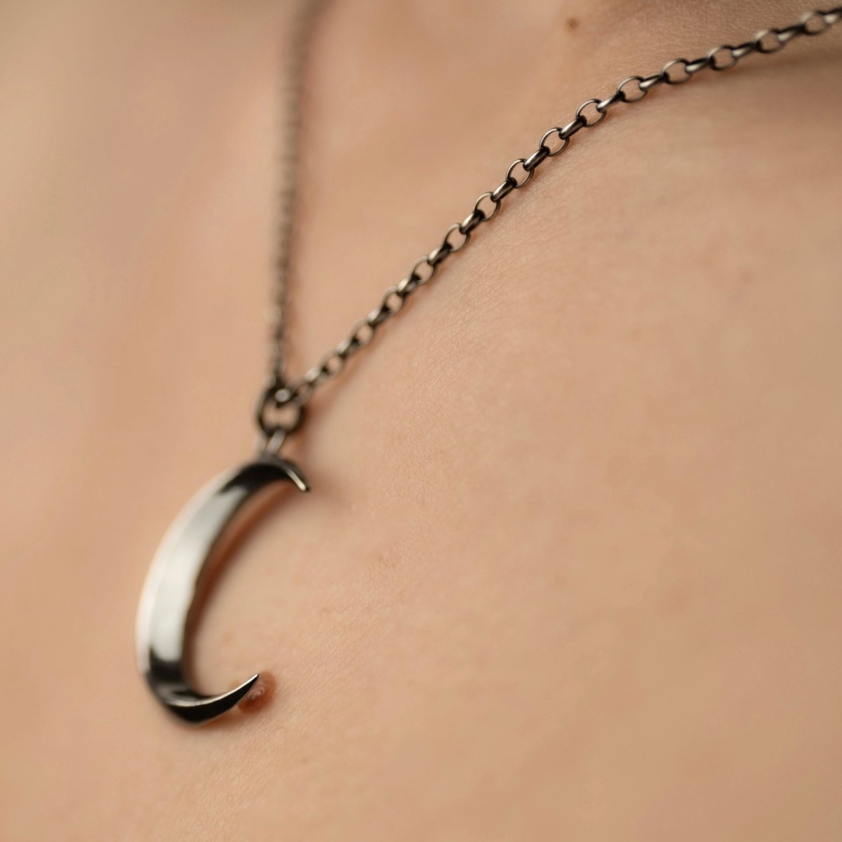 Luna pendant by Macabre Gadgets on a model, close up, focus on slim anchor chain