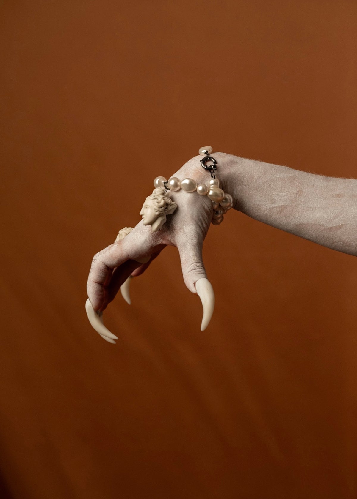 Siren’s pale foot with sharp claws adorned with rings and bracelets, detail from the Gods and Monsters THEA jewelry campaign | Macabre Gadgets