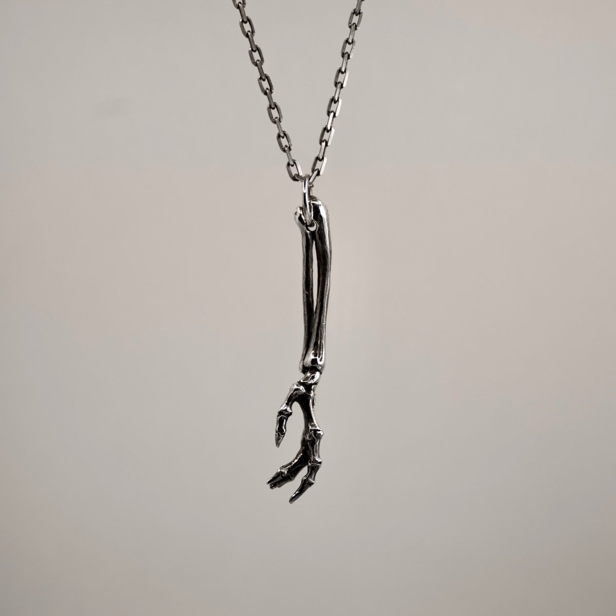 Silver Skeleton Arm pendant the view from the side showing positioning of the fingers