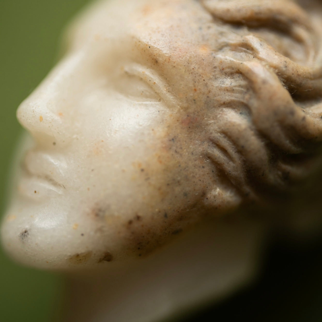 Close-up of a marble sculpture pendant of a goddess Aphrodite/Venus face with detailed features 