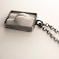 Marble Fragment pendant by Macabre Gadgets - close up of a pendant with a marble butt relief enclosed in sterling silver