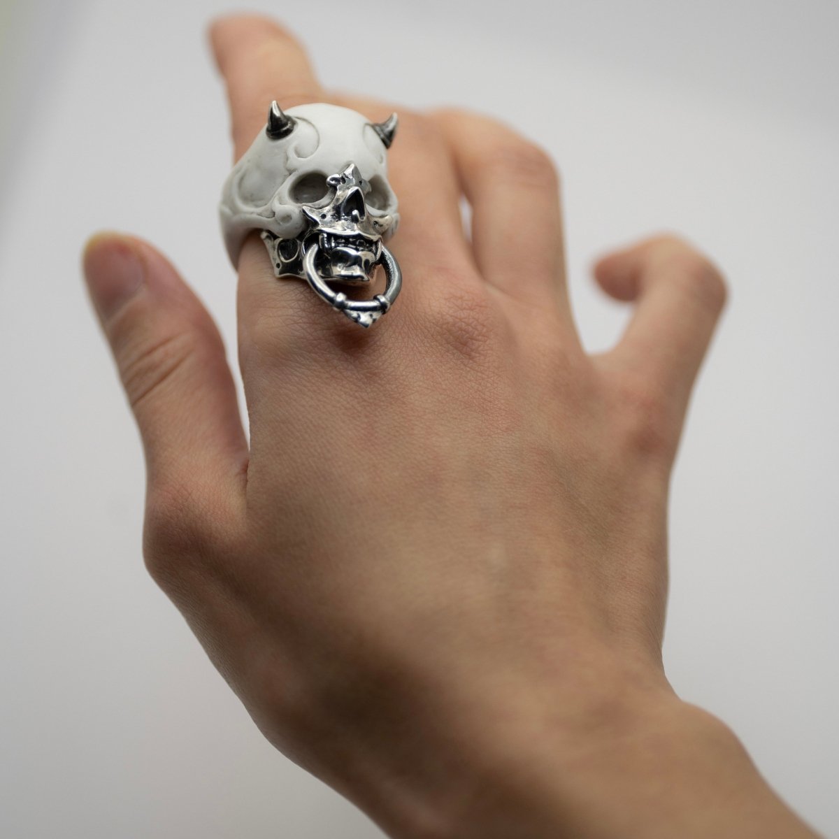 Masked Skull ring — white marble variant — worn on a woman's hand, showing scale and proportions