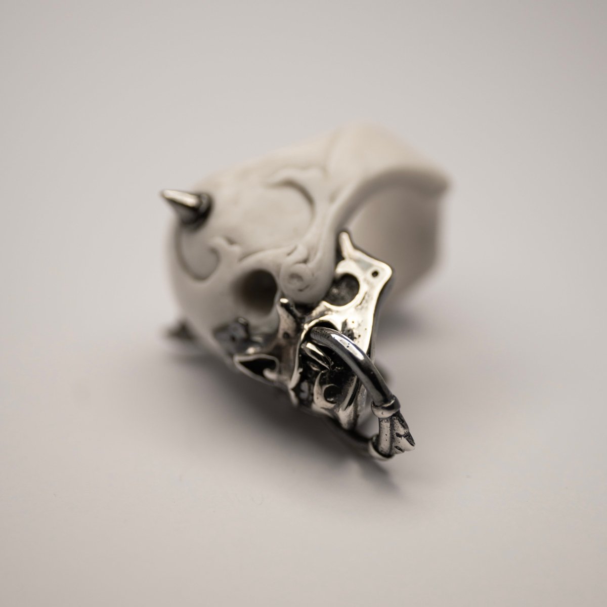 Masked Skull ring — white marble variant — side view showing ornamental marble relief and sculptural form