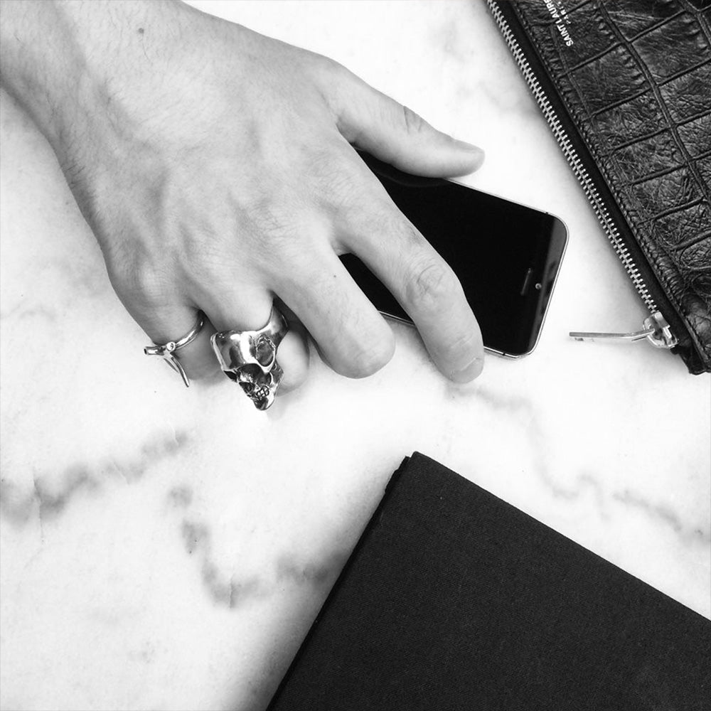 Mercury Silver Skull ring on a models hand styled with other ring