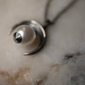 Close-up of the moon charm detail in sterling silver and large pearl with fixture