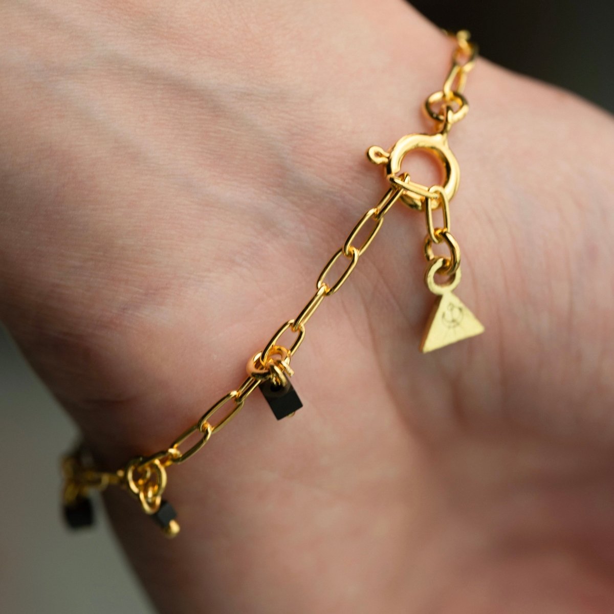 Mosaic bracelet - gold variant - close up of a lobster clasp and mini logo detail on an opposite end of the bracelet